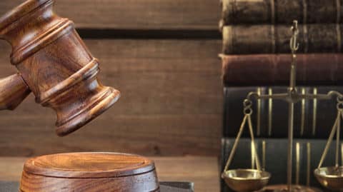 Gavel being used in revenge porn case next to scales and books