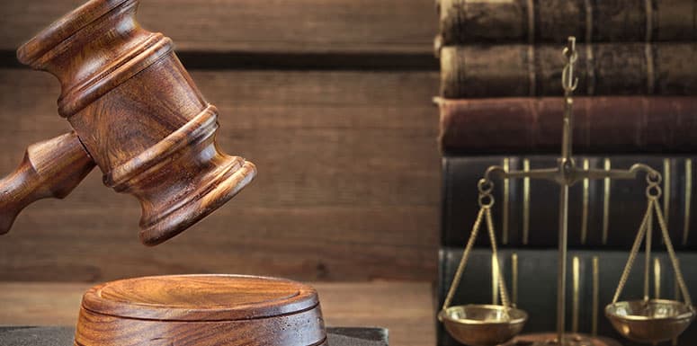 Gavel being used in revenge porn case next to scales and books