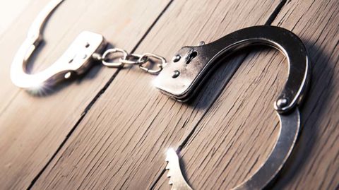 Open handcuffs on wood table