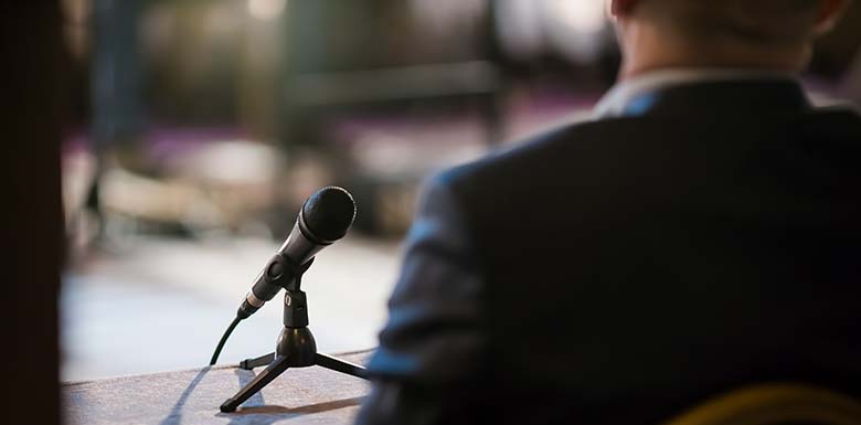 Man in suit talking into a microphone