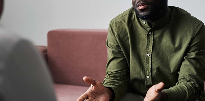 Man on sofa explaining something seriously